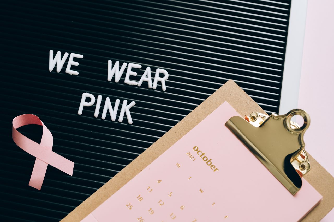 Image of a display featuring a pink ribbon, calendar, and message for breast cancer awareness.